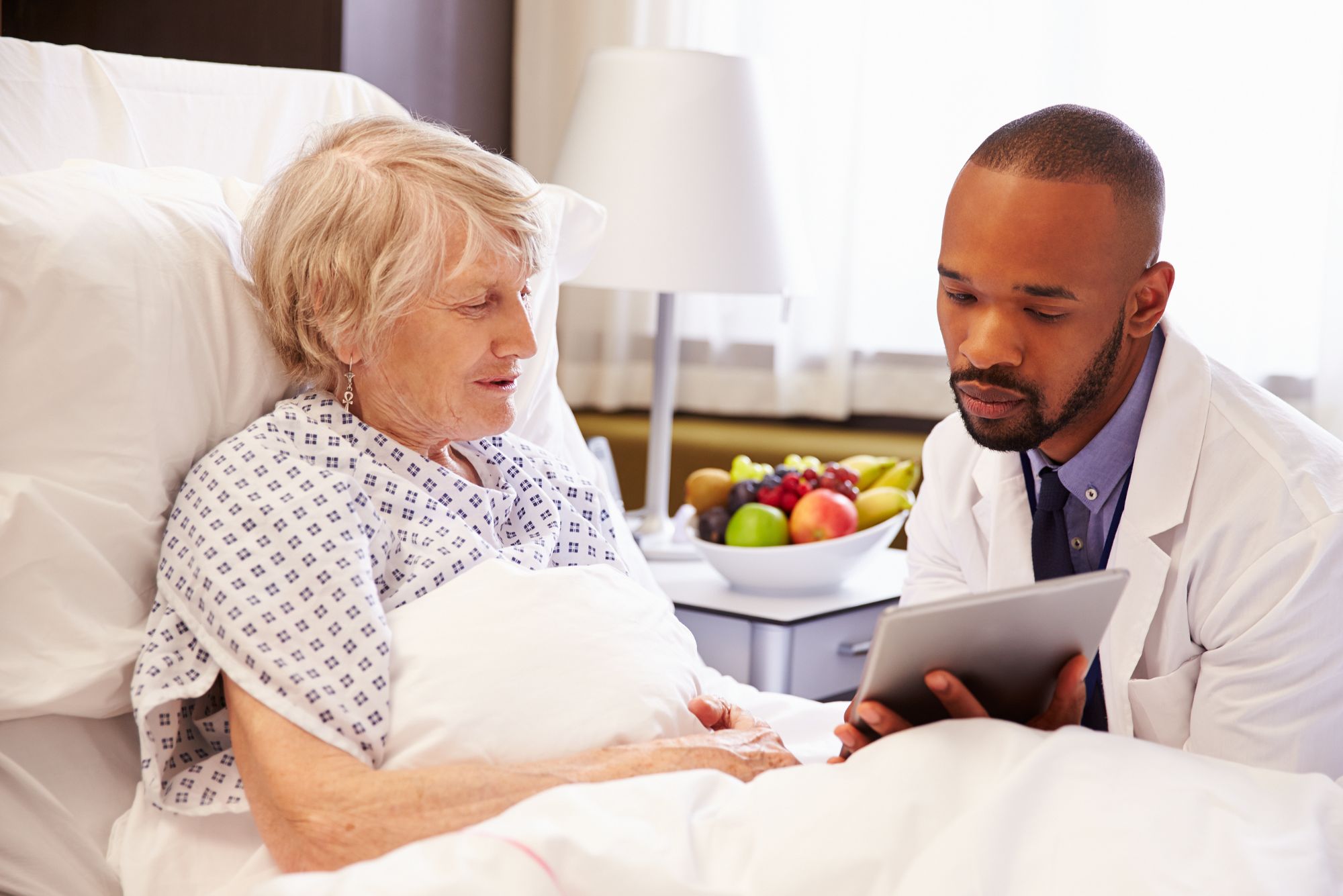 A doctor is seen showing his patient how she can provide feedback, demonstrating how to ask patients for reviews.