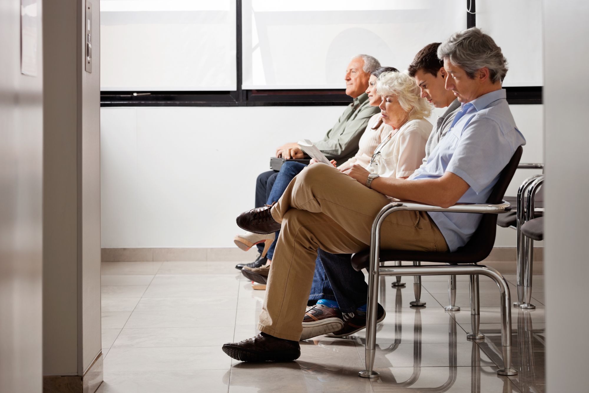 People sitting in a doctor's office waiting room because the office staff knew how to reduce no show appointments.