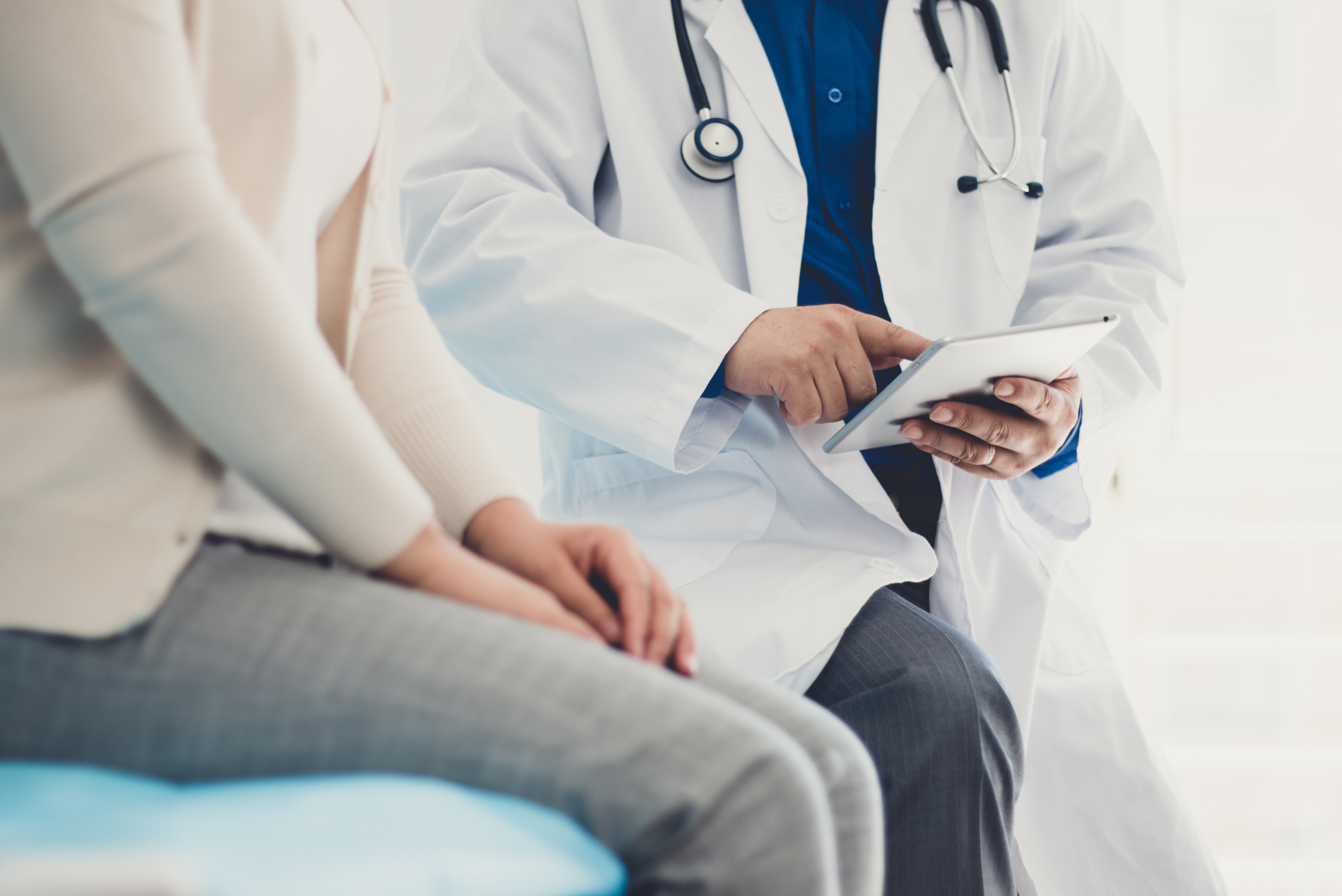 A doctor helps a patient complete an intake form on an iPad easily because her medical practice used one of Simple Interact's patient intake form templates.